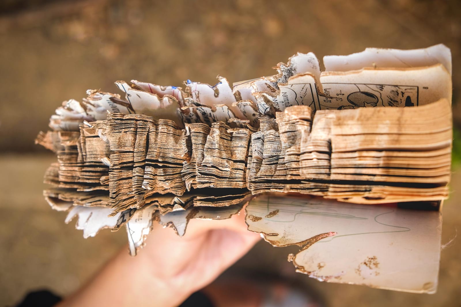 Páginas de um livro antigo, com as bordas desgastadas pelo uso e pelo tempo